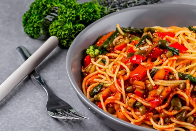 Spaghetti aux poivrons, haricots verts, petits pois et tomates pelées